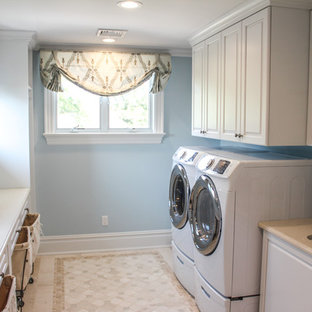 Immagine di una grande lavanderia multiuso stile shabby con lavello da incasso, ante bianche, pareti blu, pavimento con piastrelle in ceramica, lavatrice e asciugatrice affiancate e ante con bugna sagomata