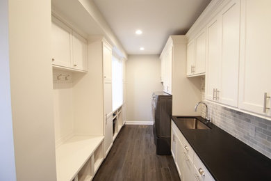 This is an example of a large traditional galley utility room in New York with a submerged sink, shaker cabinets, white cabinets, quartz worktops, grey walls, porcelain flooring and a side by side washer and dryer.