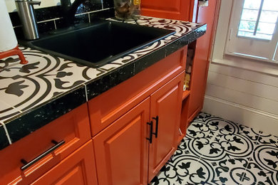 Mittelgroße Stilmix Waschküche mit Küchenrückwand in Schwarz, Rückwand aus Keramikfliesen, Porzellan-Bodenfliesen, Waschmaschine und Trockner gestapelt und schwarzem Boden in Charlotte
