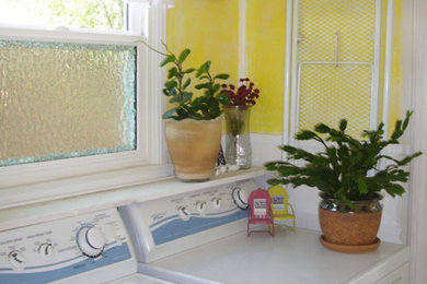 Utility room in Phoenix with yellow walls and a side by side washer and dryer.
