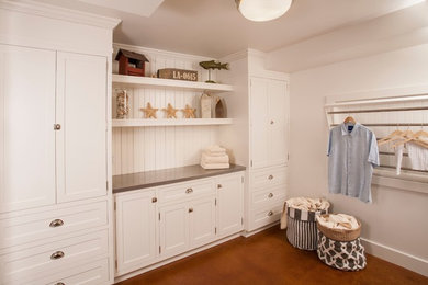 Example of a large classic u-shaped concrete floor utility room design in Seattle with a farmhouse sink, white cabinets, zinc countertops, a side-by-side washer/dryer and flat-panel cabinets