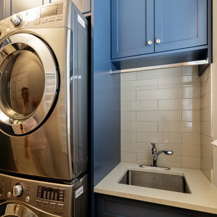 Idee per una sala lavanderia tradizionale di medie dimensioni con ante in stile shaker, ante blu, top in quarzite, pareti beige, pavimento in gres porcellanato, lavatrice e asciugatrice a colonna, pavimento beige e top beige