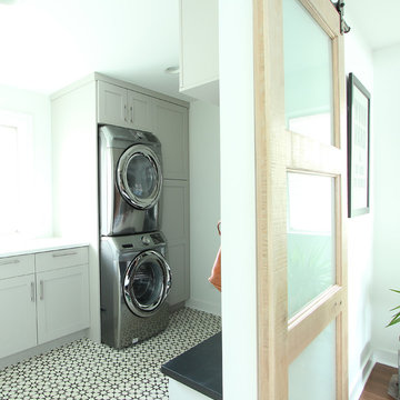 Grey Painted Cabinets in Laundry Room with Stacked Washer and Dryer