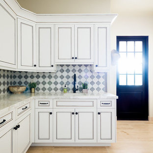 Foto di una lavanderia multiuso mediterranea di medie dimensioni con lavello sottopiano, ante in stile shaker, ante bianche, top in marmo, pareti beige, lavatrice e asciugatrice affiancate, pavimento beige, parquet chiaro e top bianco