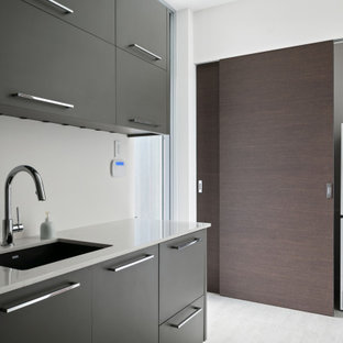 Small trendy porcelain tile and gray floor laundry closet photo in Tampa with white walls and a stacked washer/dryer