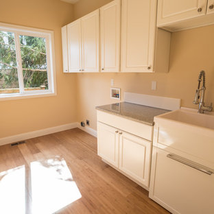 Idee per una sala lavanderia di medie dimensioni con lavello da incasso, ante con riquadro incassato, ante bianche, top alla veneziana, pareti beige, pavimento in bambù, lavatrice e asciugatrice affiancate, pavimento marrone e top multicolore