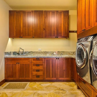 Foto di una grande sala lavanderia american style con lavello sottopiano, ante in stile shaker, ante in legno scuro, top in granito, pareti gialle e pavimento in travertino