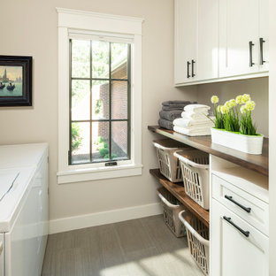 Ispirazione per una sala lavanderia chic di medie dimensioni con lavello da incasso, ante in stile shaker, ante bianche, top in legno, pareti beige, pavimento in gres porcellanato, lavatrice e asciugatrice affiancate, pavimento grigio e top marrone