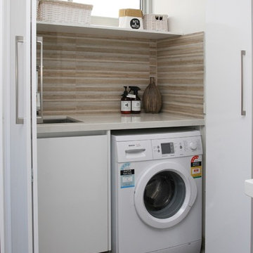 Laundry room with tiled splashback
