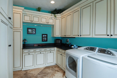 Ejemplo de lavadero clásico con puertas de armario beige, paredes azules, suelo beige y encimeras negras