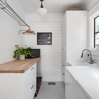 Elegant white floor dedicated laundry room photo in Orlando with an utility sink, flat-panel cabinets, white cabinets, wood countertops, white walls and a side-by-side washer/dryer