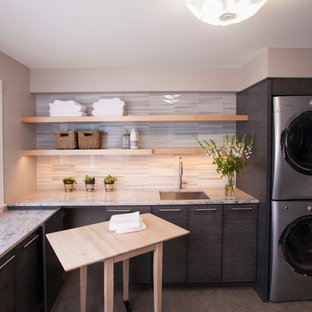 Idéer för ett mellanstort modernt l-format grovkök, med en undermonterad diskho, släta luckor, grå skåp, granitbänkskiva, beige väggar, laminatgolv, en tvättpelare och flerfärgat golv