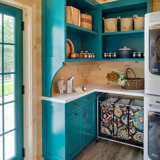 Immagine di una sala lavanderia stile rurale di medie dimensioni con pavimento con piastrelle in ceramica, ante in stile shaker, ante blu, lavatrice e asciugatrice affiancate, pavimento beige, top bianco e pareti in legno