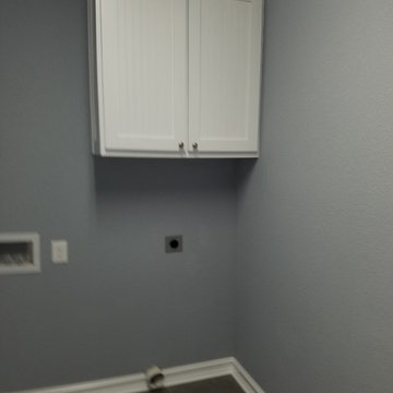 Large cabinet above dryer area in laundry room.