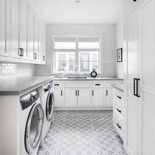 Ispirazione per una sala lavanderia costiera con lavello sottopiano, ante in stile shaker, ante bianche, pareti bianche, lavatrice e asciugatrice affiancate, pavimento multicolore e top grigio