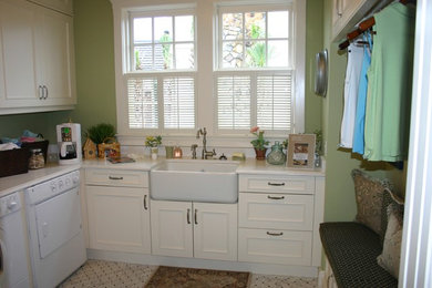 Dedicated laundry room - mid-sized country u-shaped ceramic tile dedicated laundry room idea in Tampa with a farmhouse sink, recessed-panel cabinets, white cabinets, quartz countertops, green walls and a side-by-side washer/dryer