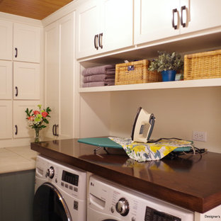 Idée de décoration pour une petit buanderie linéaire craftsman multi-usage avec un évier 1 bac, un placard à porte shaker, des portes de placard blanches, un plan de travail en bois, un mur vert, un sol en ardoise, des machines côte à côte, un plan de travail marron et un plafond en bois.