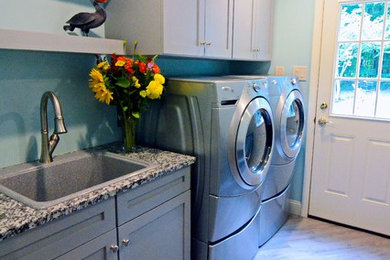 Example of a mid-sized transitional galley vinyl floor and gray floor utility room design in Philadelphia with a drop-in sink, shaker cabinets, gray cabinets, granite countertops, blue walls and a side-by-side washer/dryer