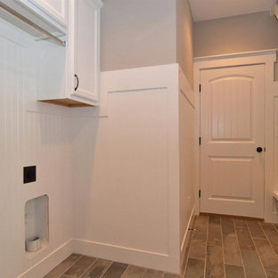 Réalisation d'une buanderie parallèle style shabby chic multi-usage et de taille moyenne avec un placard avec porte à panneau encastré, des portes de placard blanches, un mur gris, un sol en ardoise et des machines côte à côte.