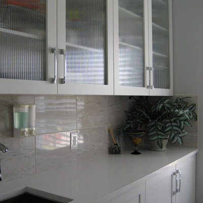 Laundry room - mid-sized contemporary laundry room idea in Other with an undermount sink, shaker cabinets, white cabinets, solid surface countertops, gray walls and a side-by-side washer/dryer