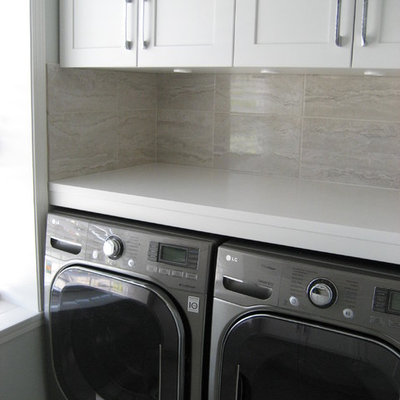 Laundry room - mid-sized contemporary laundry room idea in Other with an undermount sink, shaker cabinets, white cabinets, solid surface countertops, a side-by-side washer/dryer and gray walls
