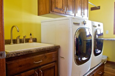 Inspiration for a mid-sized utility room remodel in Other with raised-panel cabinets, dark wood cabinets, laminate countertops and a side-by-side washer/dryer