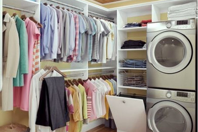 Foto di una lavanderia multiuso design di medie dimensioni con ante lisce, ante bianche, pareti gialle, parquet chiaro e lavatrice e asciugatrice a colonna