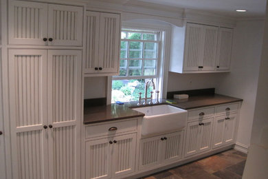 Example of a classic laundry room design in Bridgeport with a farmhouse sink, beaded inset cabinets and quartz countertops