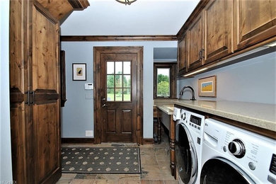 Mid-sized galley porcelain tile dedicated laundry room photo in Cleveland with an undermount sink, raised-panel cabinets, medium tone wood cabinets, quartz countertops, blue walls and a side-by-side washer/dryer