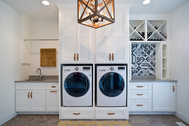 Example of a minimalist single-wall brick floor and multicolored floor utility room design in Other with an undermount sink, raised-panel cabinets, white cabinets, quartz countertops, white walls and a side-by-side washer/dryer
