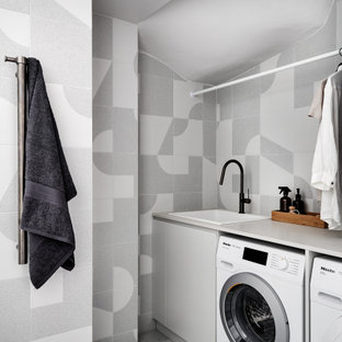 Design ideas for a small scandinavian single-wall utility room in Sydney with a drop-in sink, quartz benchtops, grey walls, porcelain floors, a side-by-side washer and dryer, grey floor and white benchtop.
