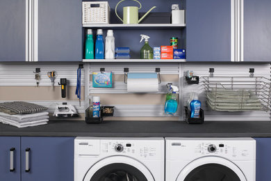 Ejemplo de lavadero multiusos y lineal contemporáneo con armarios con paneles lisos, puertas de armario azules, encimera de laminado, lavadora y secadora juntas, paredes beige y encimeras grises