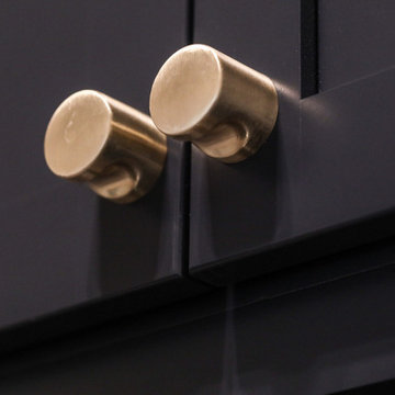 Laundry with Gold Hardware on Navy Cabinets