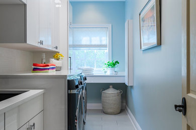 Example of a mid-sized transitional l-shaped ceramic tile and beige floor dedicated laundry room design in New Orleans with an undermount sink, flat-panel cabinets, white cabinets, quartzite countertops, a side-by-side washer/dryer, white countertops and blue walls