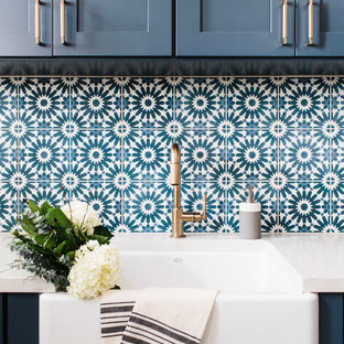 Immagine di una sala lavanderia minimalista di medie dimensioni con lavello stile country, ante in stile shaker, ante blu, top in quarzite, pareti bianche, pavimento con piastrelle in ceramica, lavatrice e asciugatrice affiancate, pavimento multicolore e top bianco