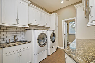 Laundry room - large transitional galley porcelain tile laundry room idea in Orlando with shaker cabinets, white cabinets, quartz countertops, beige walls, a side-by-side washer/dryer and an undermount sink