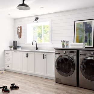 Inspiration pour une buanderie linéaire rustique multi-usage et de taille moyenne avec un évier encastré, un placard à porte shaker, des portes de placard blanches, un mur blanc, un sol en bois clair, des machines côte à côte, un sol beige, un plan de travail gris et du lambris de bois.