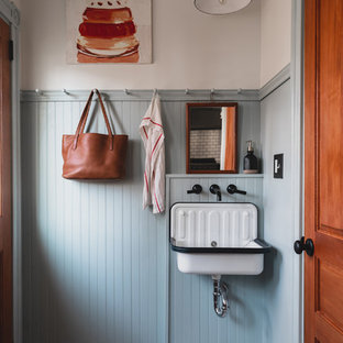 Inspiration pour une petit buanderie traditionnelle multi-usage avec un évier utilitaire, un placard avec porte à panneau encastré, des portes de placard bleues, un mur bleu, un sol en bois peint, des machines superposées et un sol bleu.
