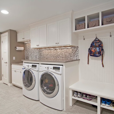 Utility room - large traditional single-wall ceramic tile and gray floor utility room idea in Minneapolis with white cabinets, a side-by-side washer/dryer, an undermount sink, shaker cabinets, solid surface countertops, beige countertops and gray walls