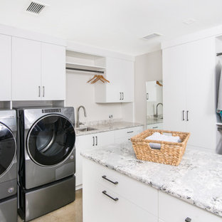 Mid-sized minimalist u-shaped concrete floor laundry closet photo in Detroit with an undermount sink, flat-panel cabinets, white cabinets, quartzite countertops, white walls and a side-by-side washer/dryer