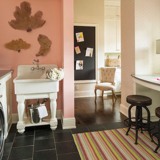 Inspiration för en vintage tvättstuga, med vita skåp, svart golv, en allbänk, skåp i shakerstil, rosa väggar och en tvättmaskin och torktumlare bredvid varandra
