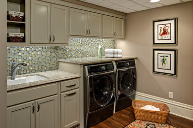 Inspiration for a large classic single-wall utility room in Minneapolis with a submerged sink, shaker cabinets, beige cabinets, granite worktops, beige walls, medium hardwood flooring and a side by side washer and dryer.