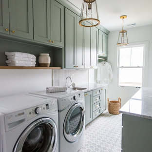 Immagine di una sala lavanderia stile americano di medie dimensioni con ante in stile shaker, ante verdi, top in marmo, pareti bianche, lavatrice e asciugatrice affiancate, pavimento in cemento e lavello sottopiano