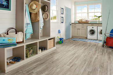 Beach style vinyl floor laundry room photo in Columbus with flat-panel cabinets, beige cabinets, blue walls and a side-by-side washer/dryer