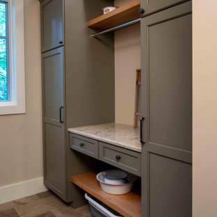 Bild på en mellanstor parallell tvättstuga enbart för tvätt, med en undermonterad diskho, luckor med infälld panel, grå skåp, flerfärgad stänkskydd, beige väggar, klinkergolv i porslin, en tvättmaskin och torktumlare bredvid varandra och flerfärgat golv