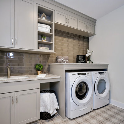 Utility room - traditional single-wall multicolored floor utility room idea in Other with an undermount sink, shaker cabinets, gray cabinets, beige walls, a side-by-side washer/dryer and gray countertops