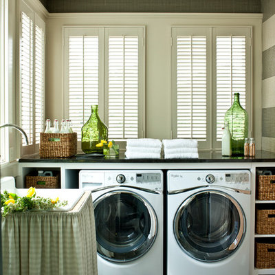 Inspiration for a large cottage slate floor laundry room remodel in Nashville with white cabinets, onyx countertops, a side-by-side washer/dryer, open cabinets, black countertops, a drop-in sink and gray walls