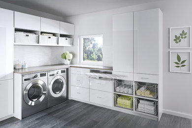 Idéer för att renovera en stor funkis l-formad tvättstuga enbart för tvätt, med vita skåp, vita väggar, en tvättmaskin och torktumlare bredvid varandra, släta luckor, laminatbänkskiva och linoleumgolv
