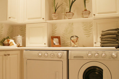 Example of a mid-sized dedicated laundry room design in New York with white cabinets and a side-by-side washer/dryer
