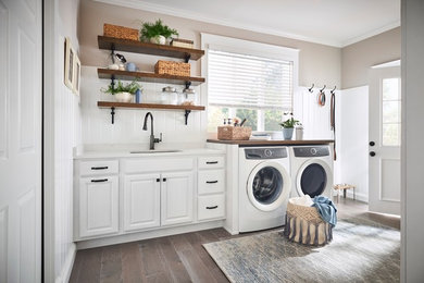 他の地域にある中くらいなトランジショナルスタイルのおしゃれな洗濯室 (ll型、レイズドパネル扉のキャビネット、白いキャビネット) の写真